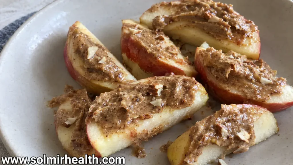 Sliced apple wedges topped with almond butter, chia seeds, and cinnamon