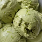 Avocado lime ice cream in a bowl with lime wedge