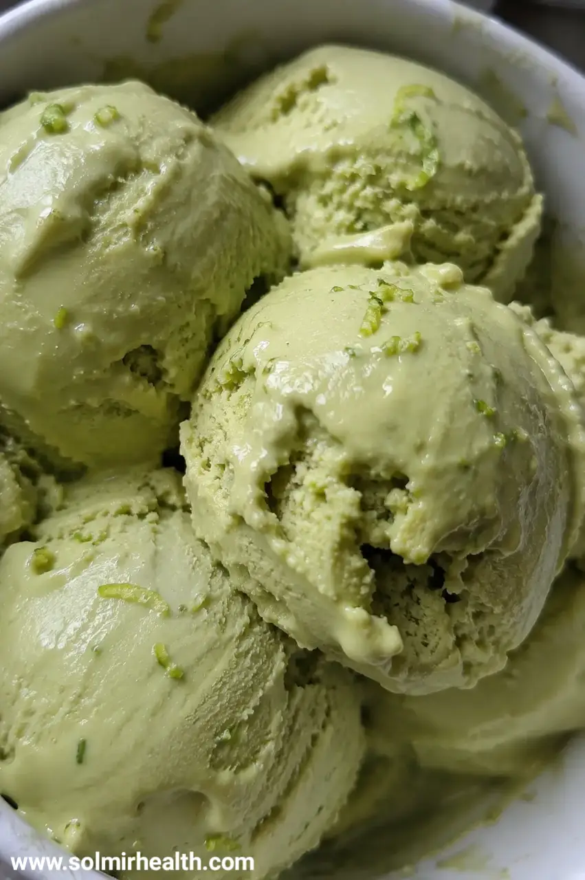 Avocado lime ice cream in a bowl with lime wedge