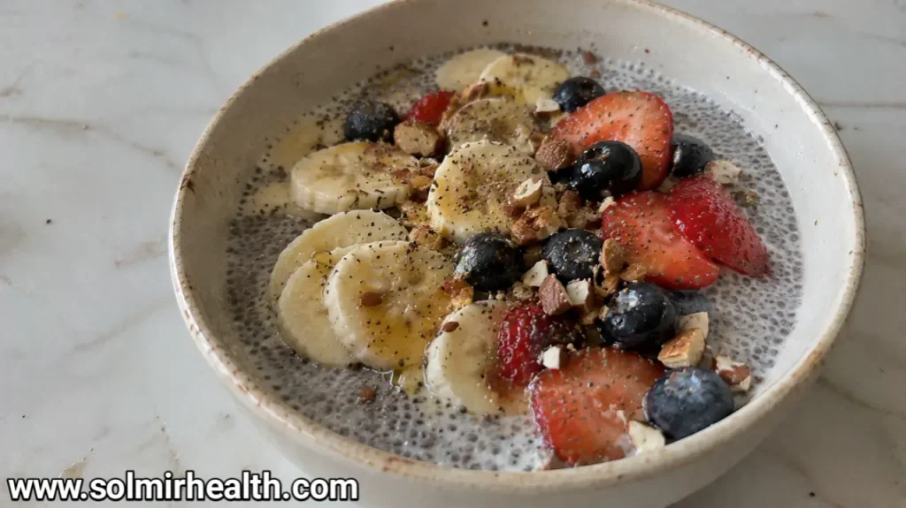 Chia pudding in a glass bowl topped with berries and chopped walnuts