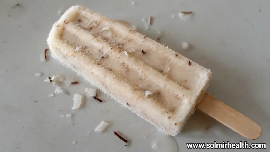 Coconut protein popsicles with a pale, creamy texture and shredded coconut on top.