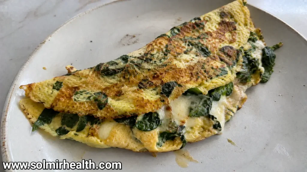  Folded spinach and cheddar omelette on a white plate