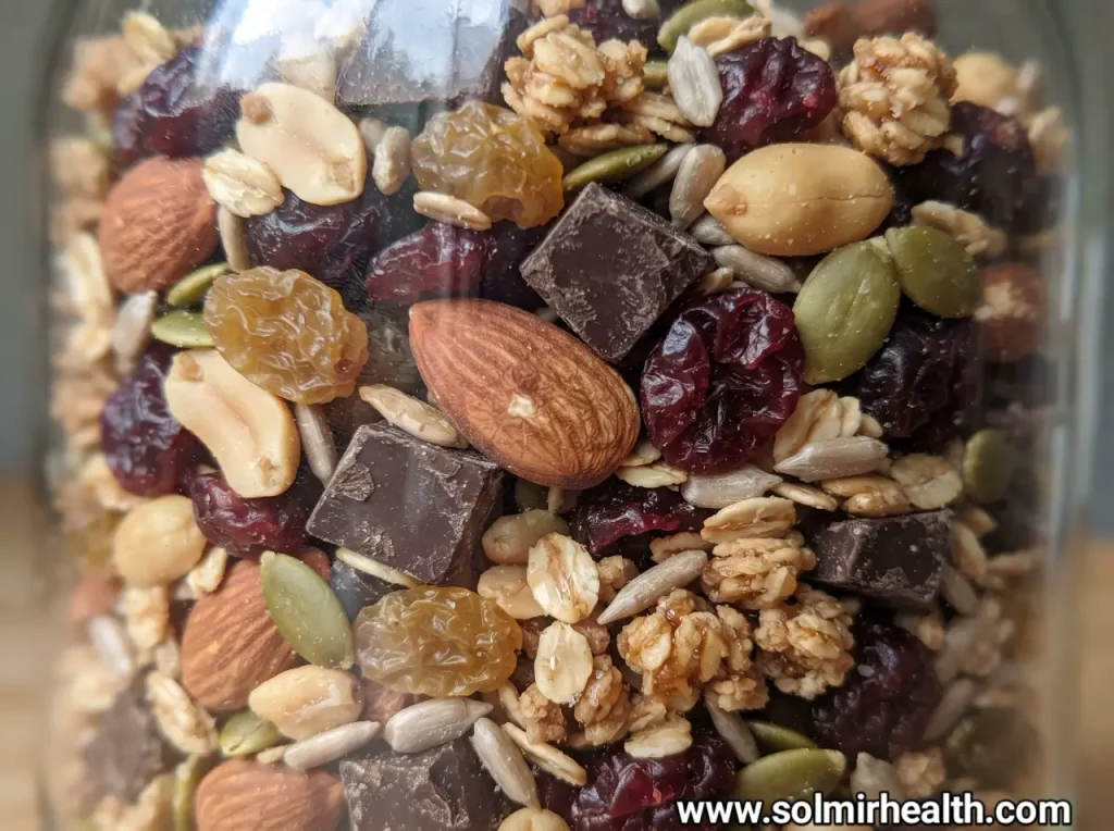 Glass jar filled with almonds, peanuts, pumpkin seeds and dried cranberries