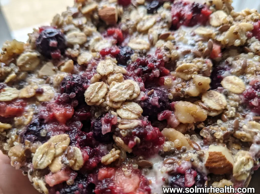 Broken pieces of healthy sweet snacks frozen Greek yogurt bark topped with fresh berries and chopped nuts